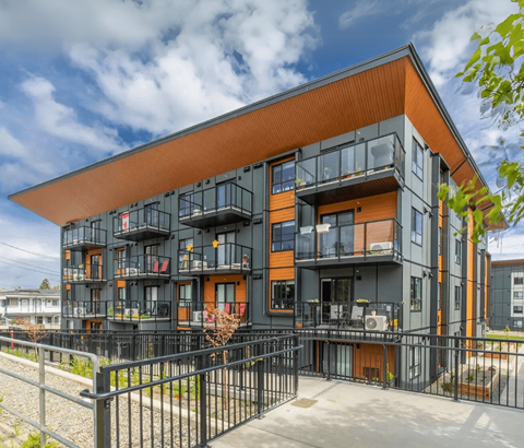 A modern building with black and orange exterior and balconies.
