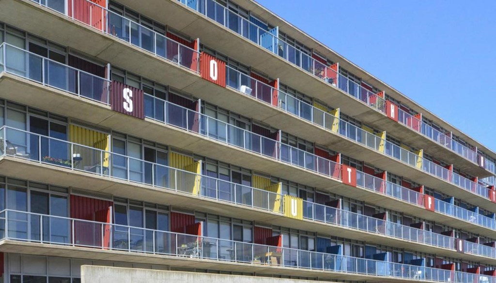the facade of a building with colorful windows and balconies
