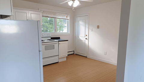 a kitchen with white appliances and a white door