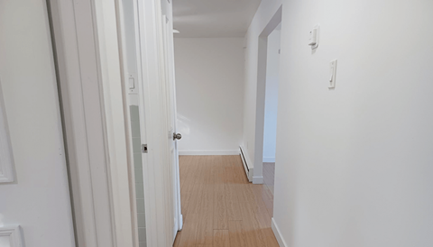 an empty room with white walls and a wooden floor