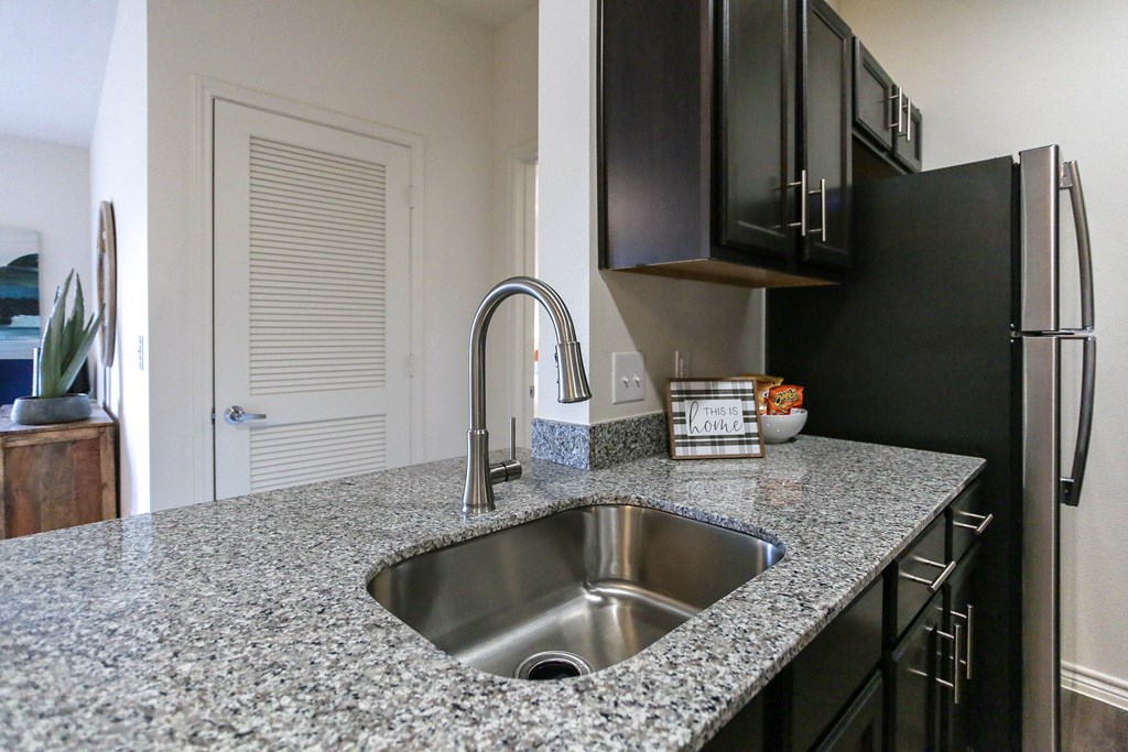 a kitchen with granite countertops and a stainless steel sink