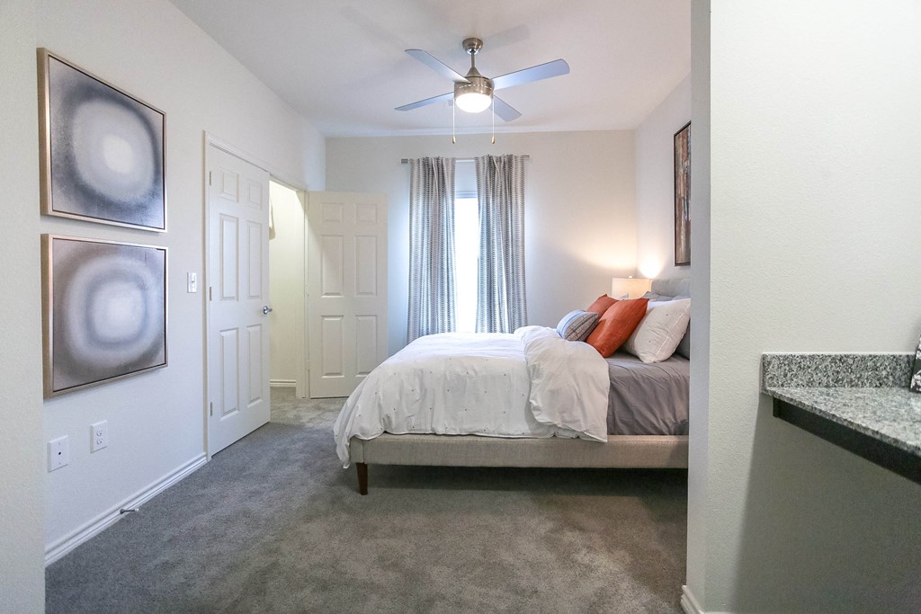 a bedroom with a bed and a ceiling fan