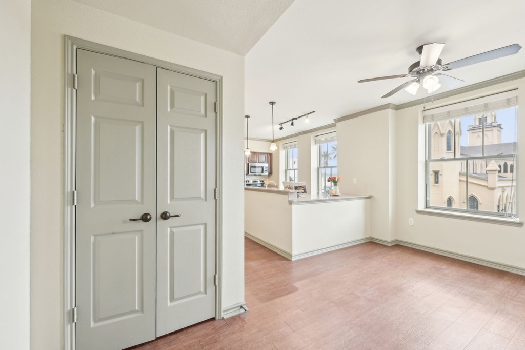 A room with a white door and a ceiling fan.