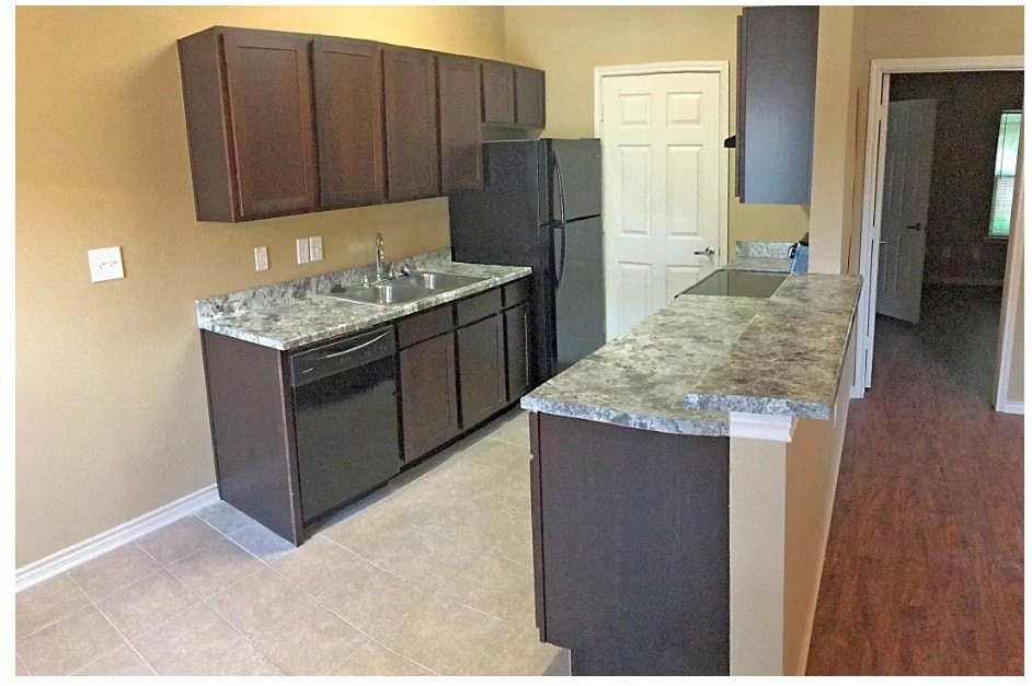 a kitchen with an island and a refrigerator