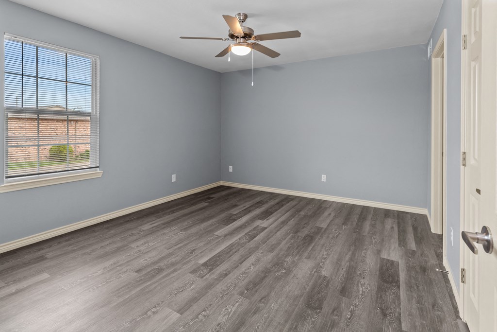 a bedroom with hardwood floors and a ceiling fan