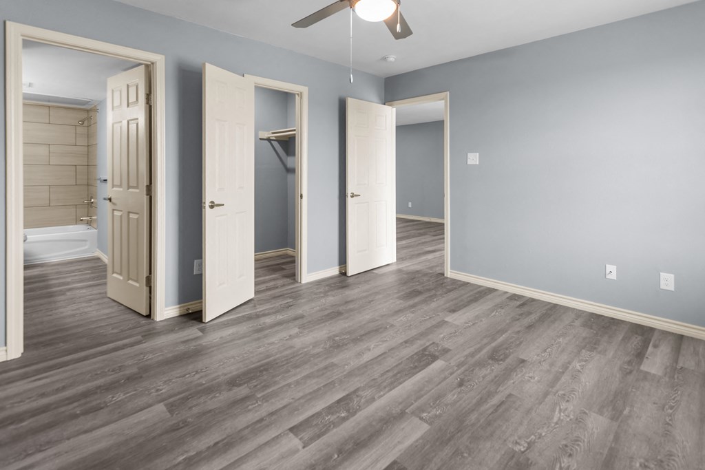 a bedroom with hardwood floors and blue walls