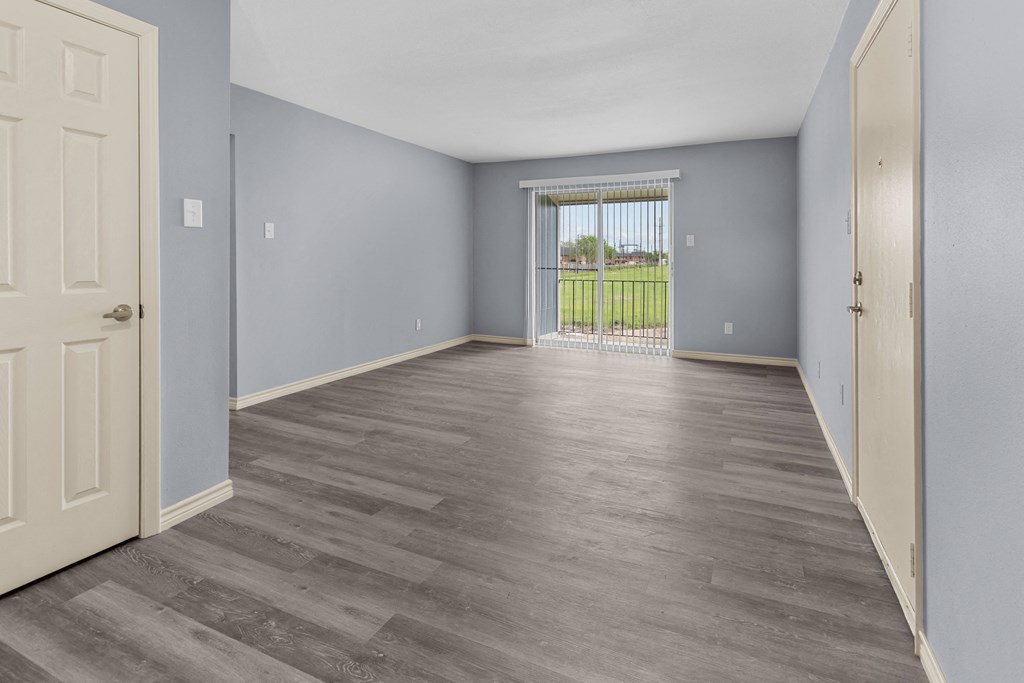 a bedroom with hardwood flooring and a door leading to a balcony