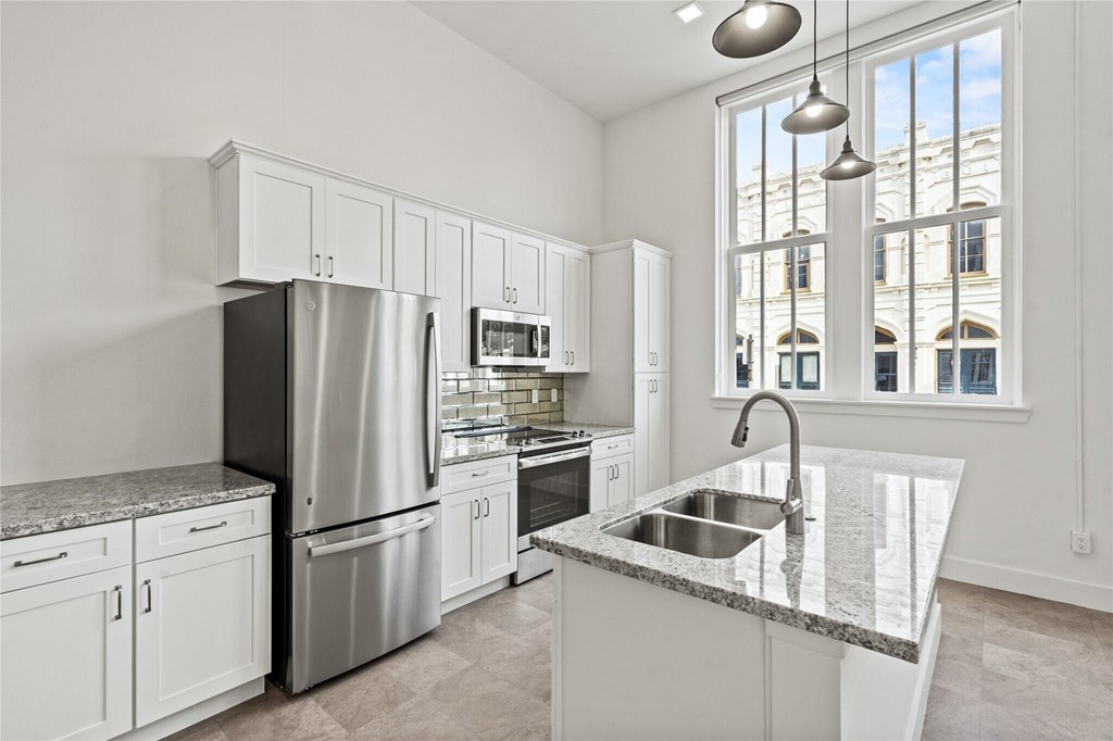 A modern kitchen with stainless steel appliances and white cabinets.