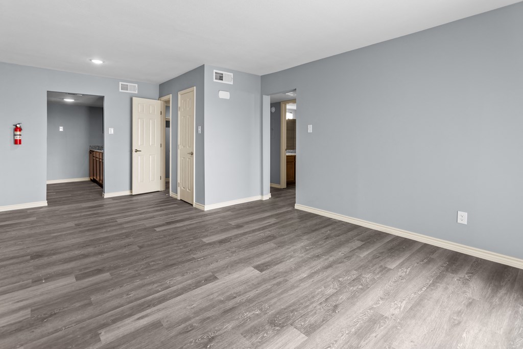 a bedroom with gray walls and a hardwood floor
