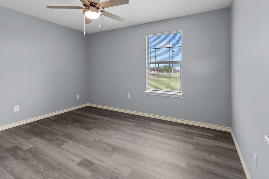 a bedroom with gray walls and a ceiling fan