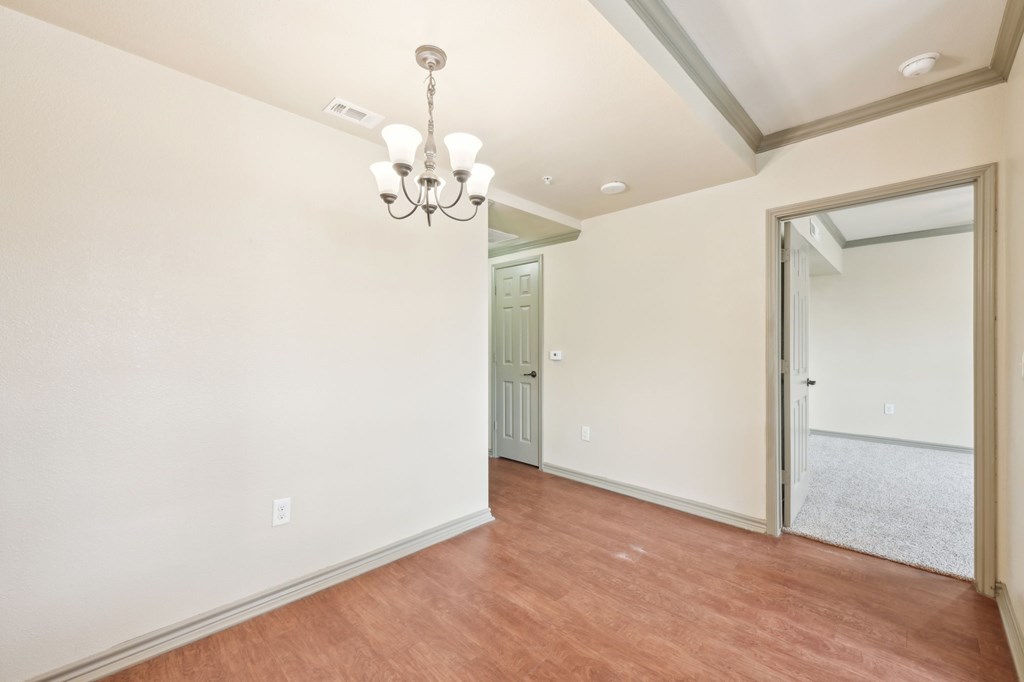 A room with a wooden floor and a chandelier.