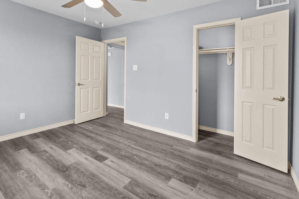 a bedroom with a ceiling fan and a closet