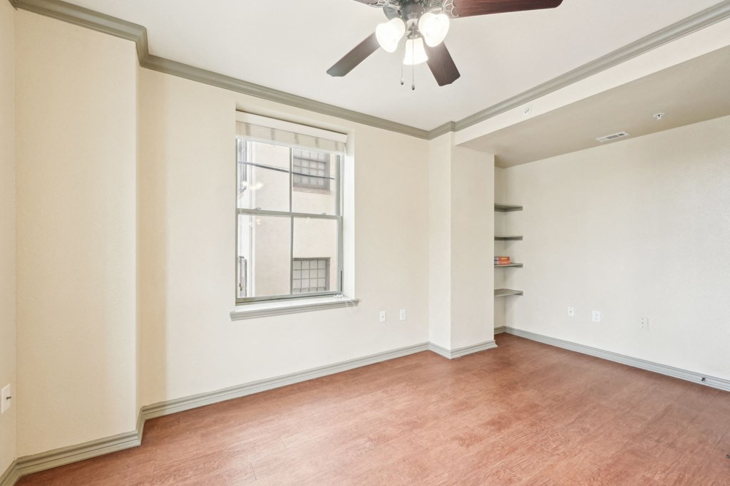 A room with a ceiling fan and a window.