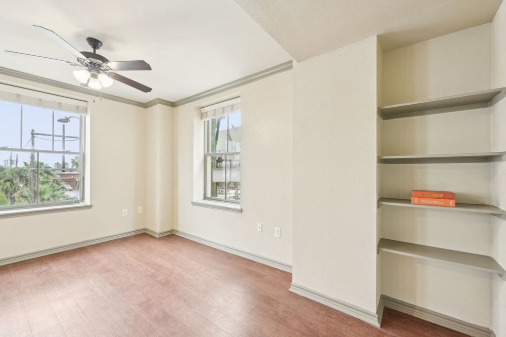 Empty room with a ceiling fan and a window.