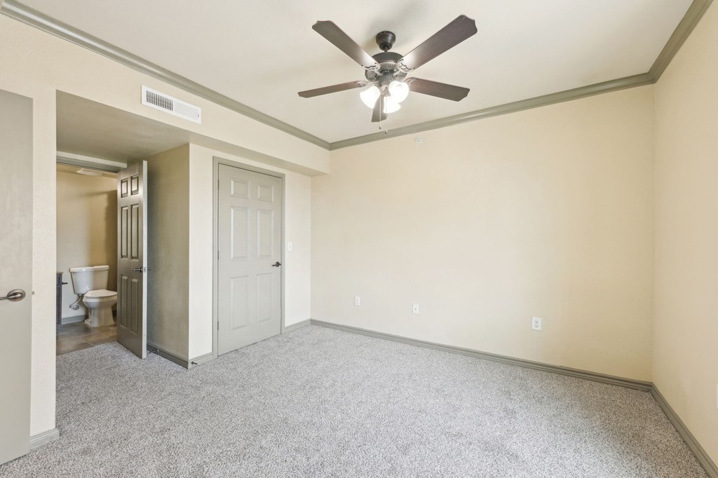 A room with a ceiling fan and a carpeted floor.