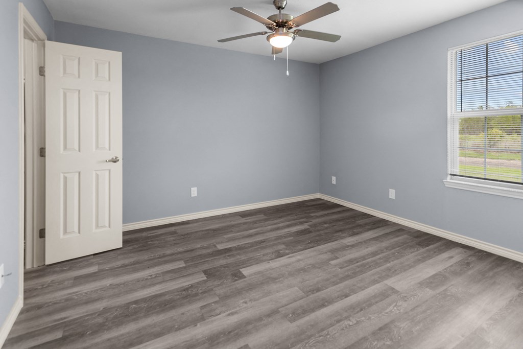 a bedroom with hardwood floors and a ceiling fan