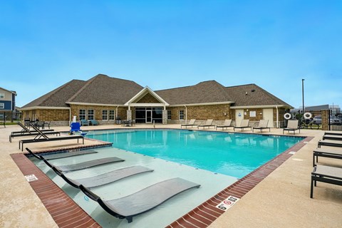 A large swimming pool with a building in the background.