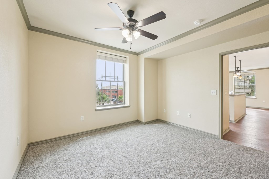 A room with a ceiling fan and a window.