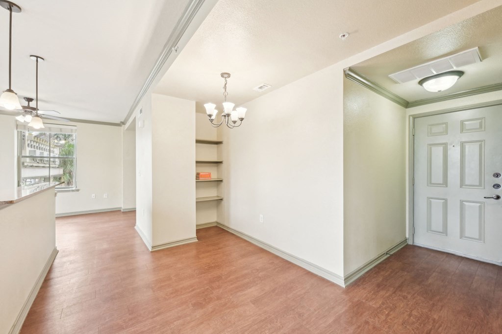 A room with a white door and a chandelier hanging from the ceiling.