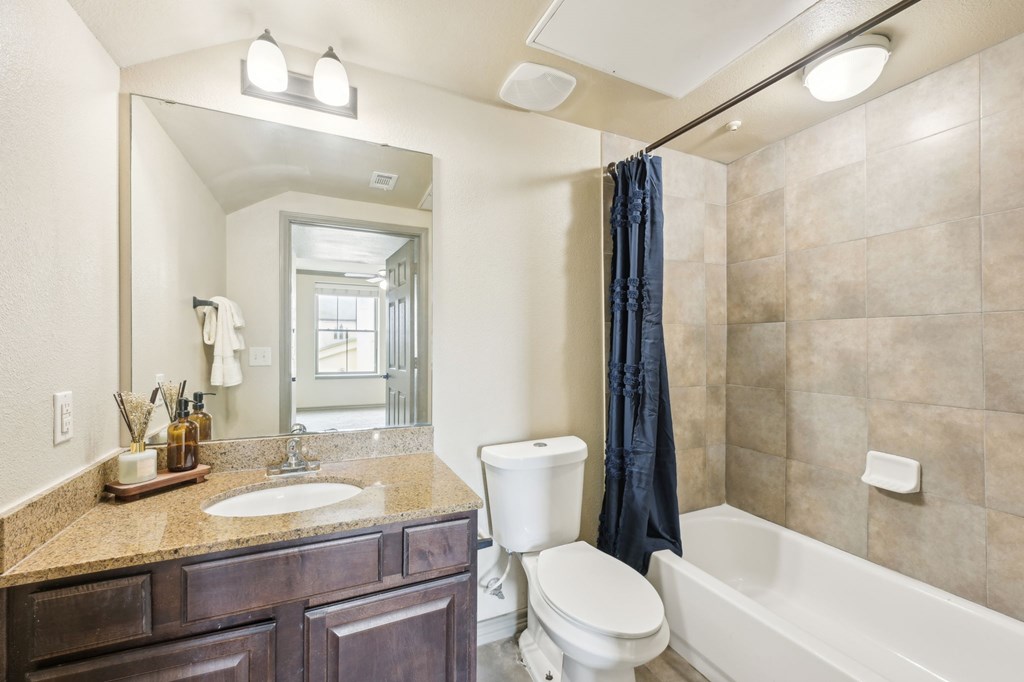 A bathroom with a sink, toilet, and bathtub.