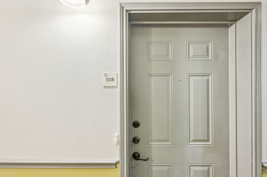 A white door with a black handle and a number 508 on the wall.