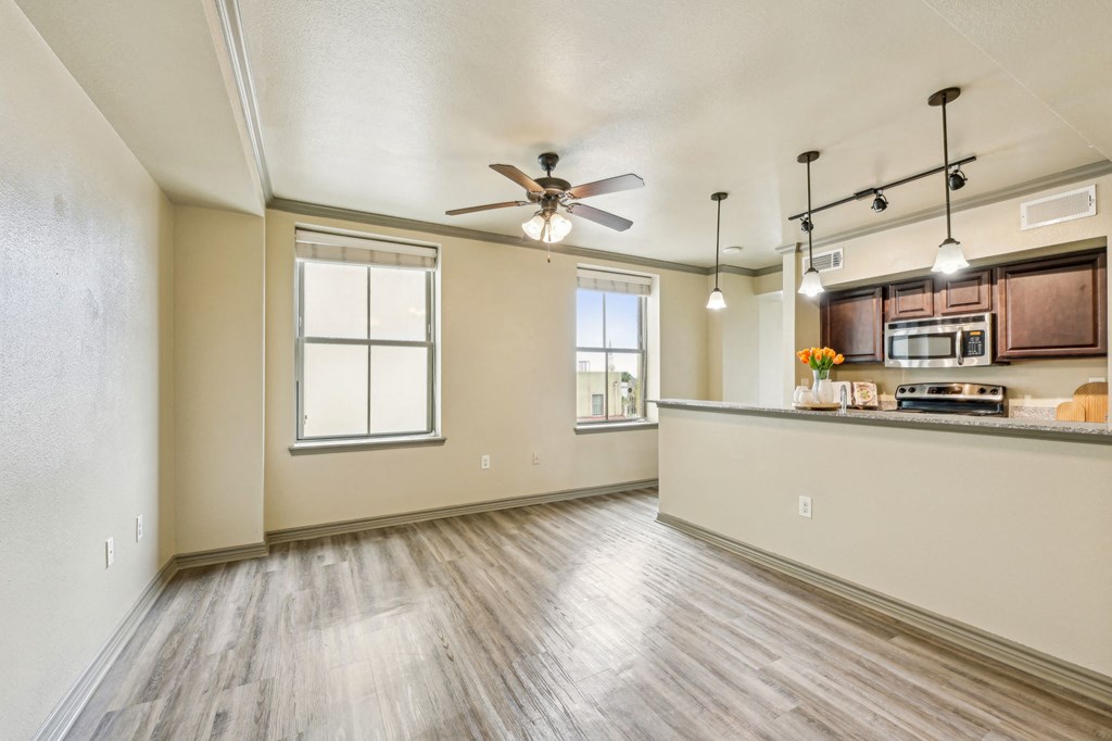 A spacious room with a ceiling fan and wooden flooring.