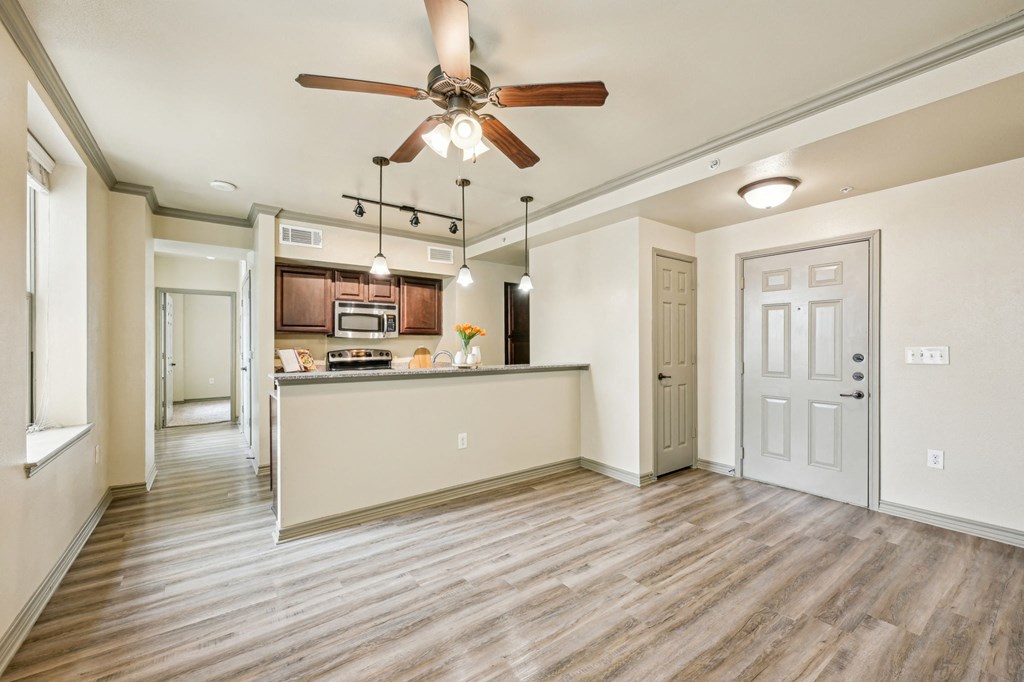A kitchen with a ceiling fan and wooden floors.