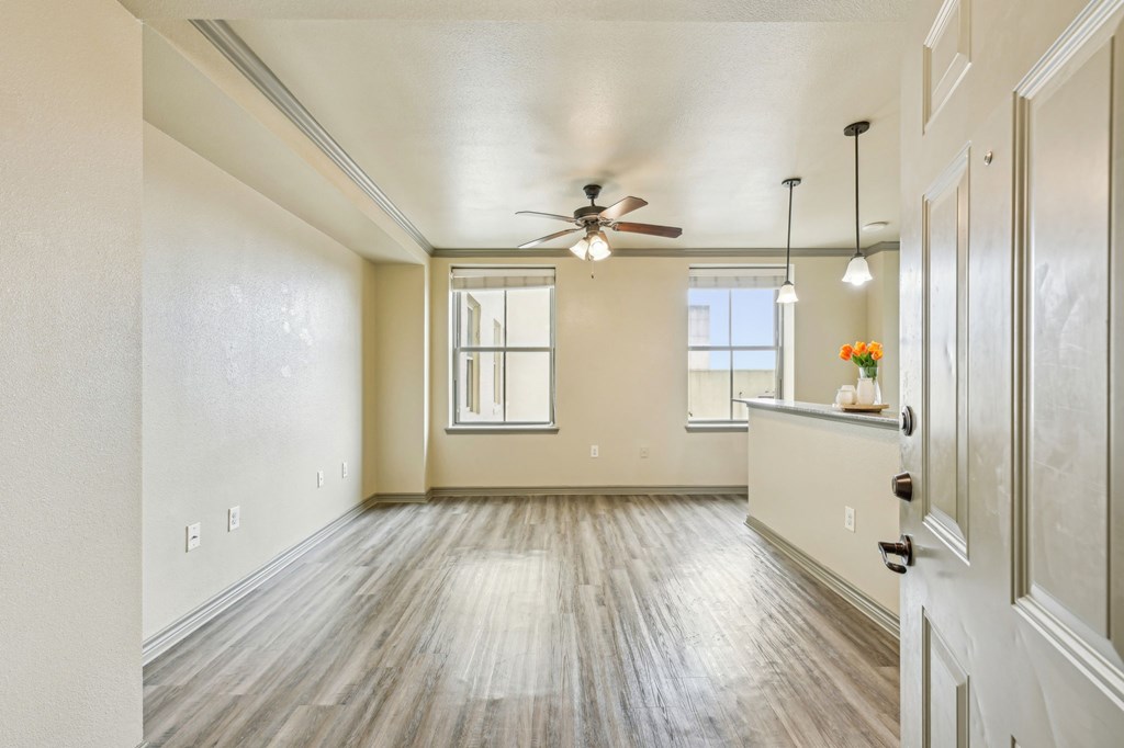 A spacious room with a ceiling fan and lighting fixtures.
