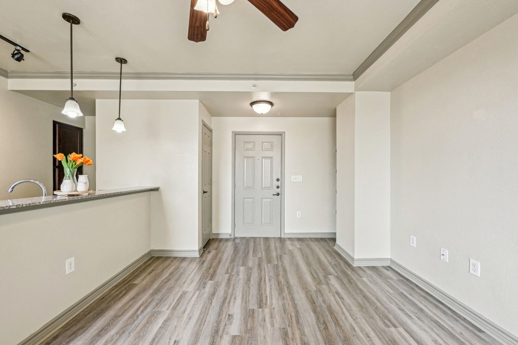 A room with a white door and a white ceiling fan.