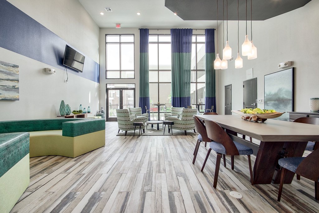 a resident clubhouse with a table with chairs and a couch