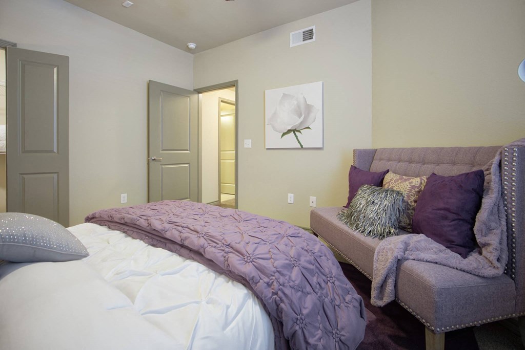 a bedroom with a large bed and a chair