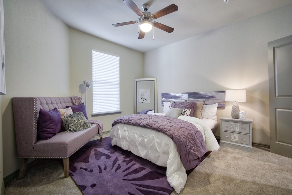 a bedroom with a bed and a ceiling fan