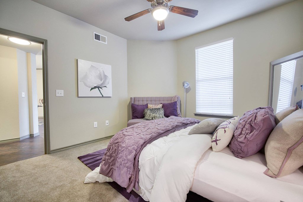 a bedroom with a large bed and a ceiling fan