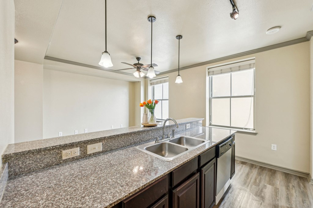 A kitchen with granite countertops and a window.