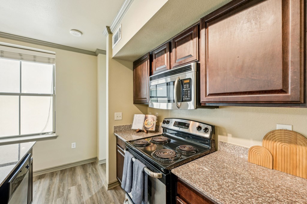 A kitchen with a black stove top oven and a microwave above it.