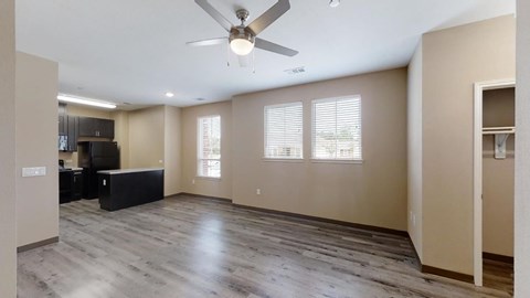 A spacious room with a ceiling fan and wooden flooring.