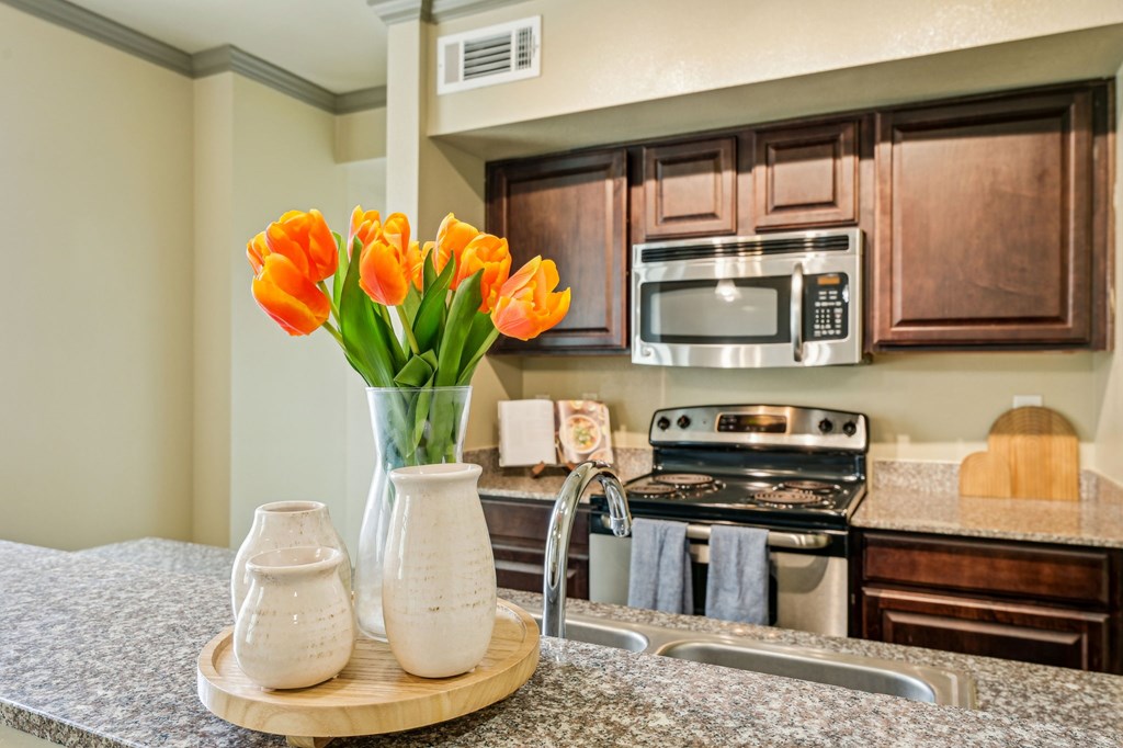A kitchen with brown cabinets and a stove top oven.