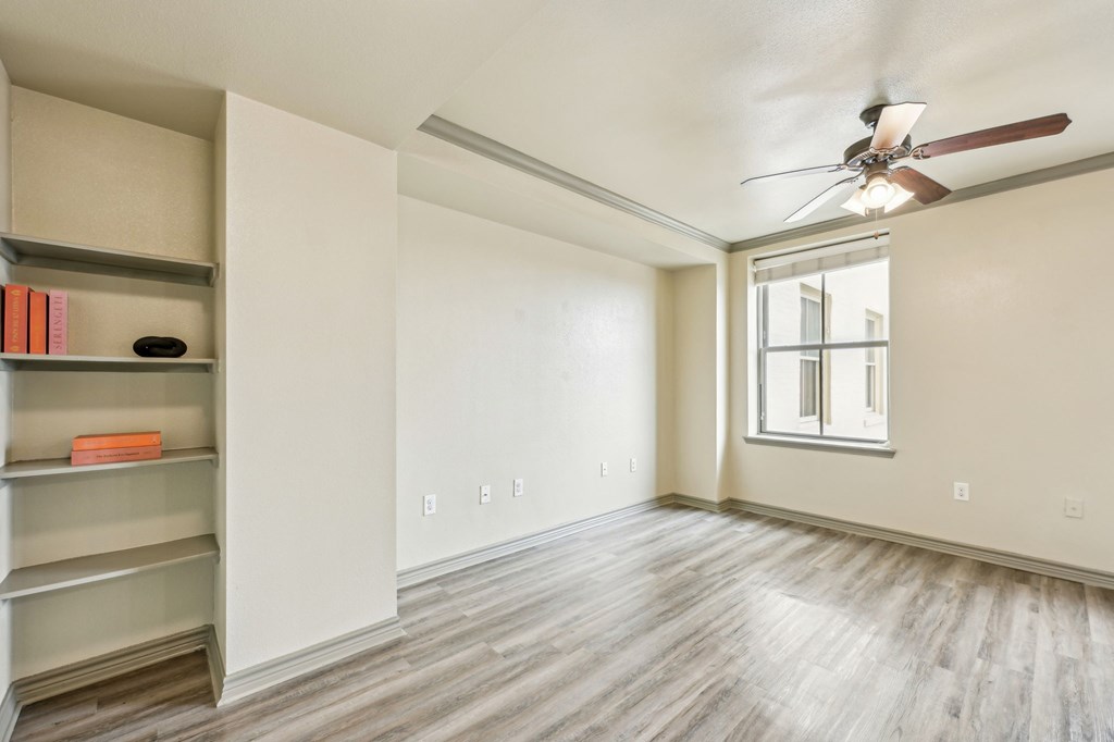 A room with a ceiling fan and a window.