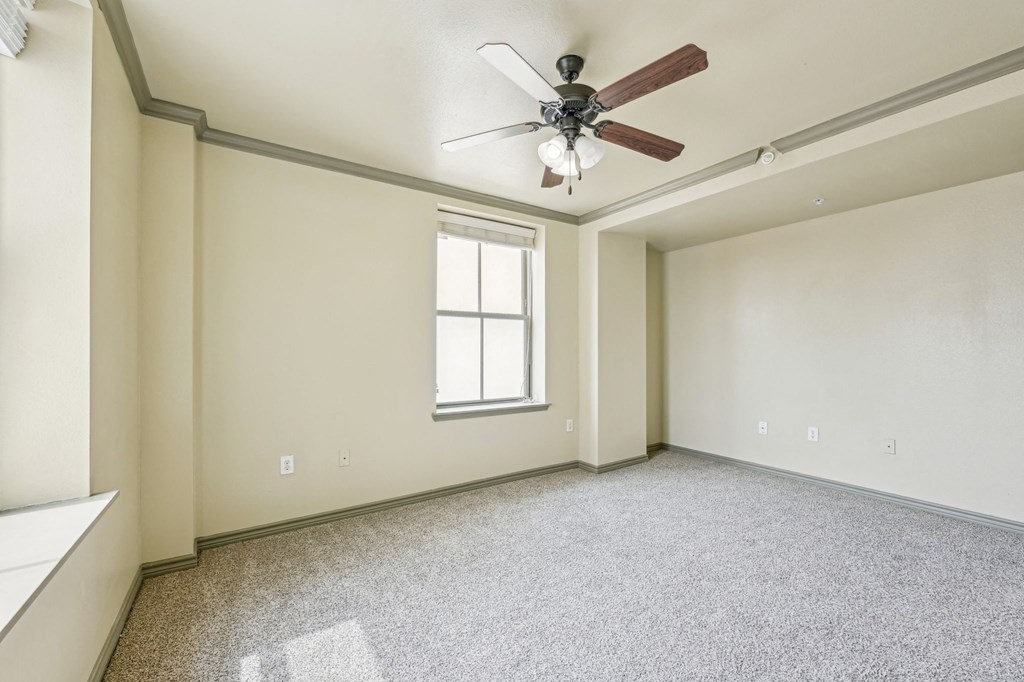 A room with a ceiling fan and a window.