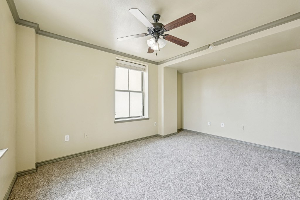 A room with a ceiling fan and a window.