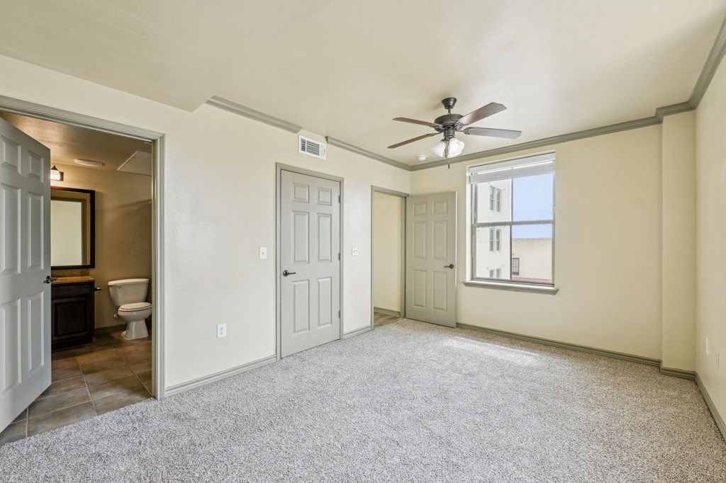 A room with a ceiling fan and a window.
