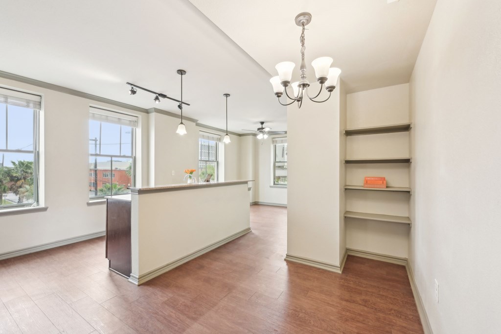 A room with a chandelier, a window, and a counter.