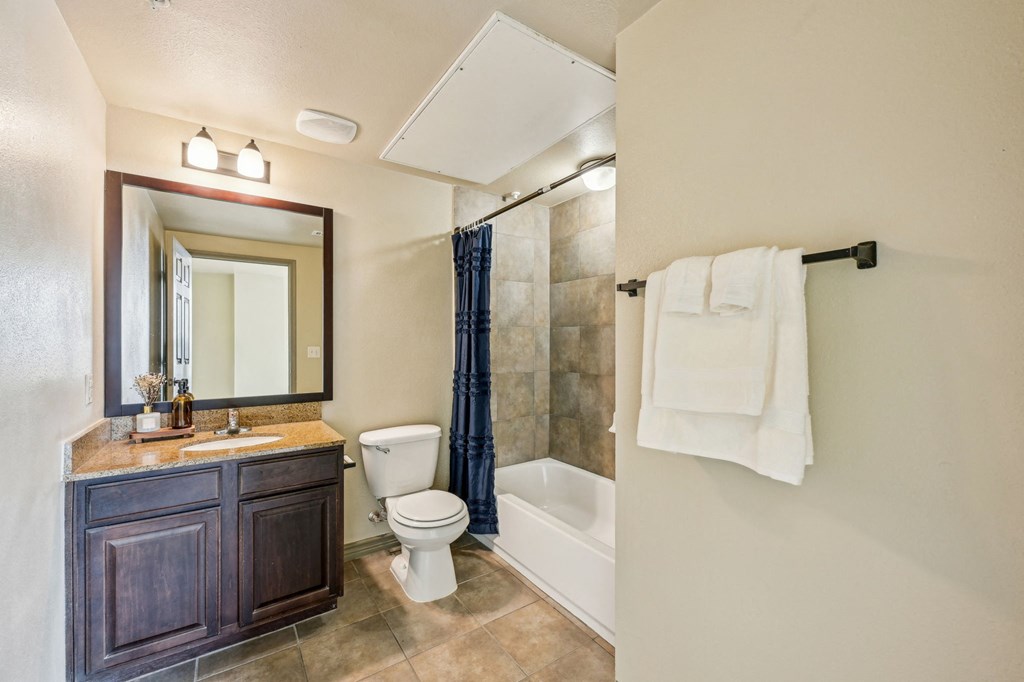 A bathroom with a toilet, sink, and shower.
