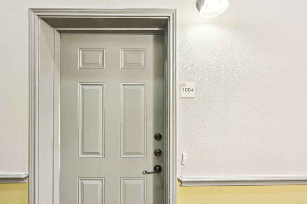 A white door with a number 1004 on the wall above it.