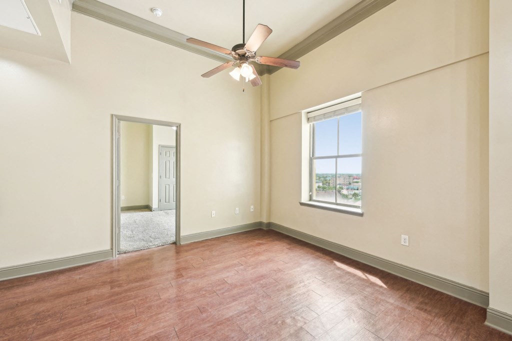 A room with a ceiling fan and a window.