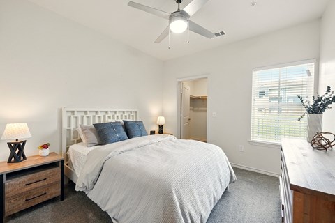 A bedroom with a large bed and a ceiling fan.