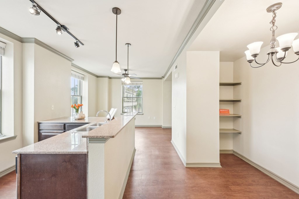 A kitchen with a brown counter top and white walls.