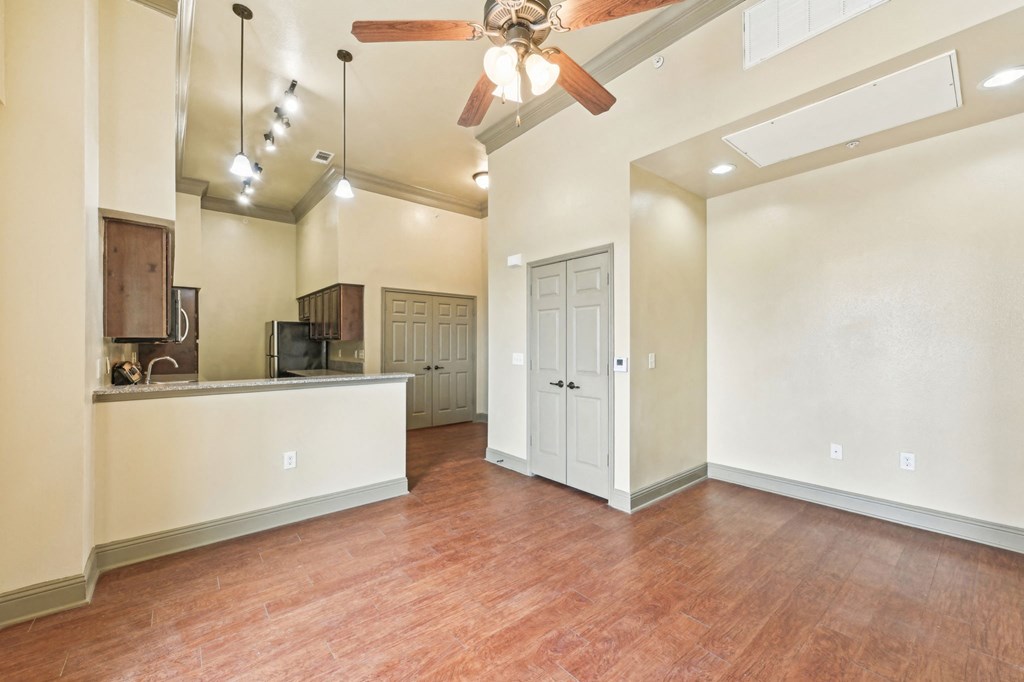 A room with a ceiling fan and wooden floors.