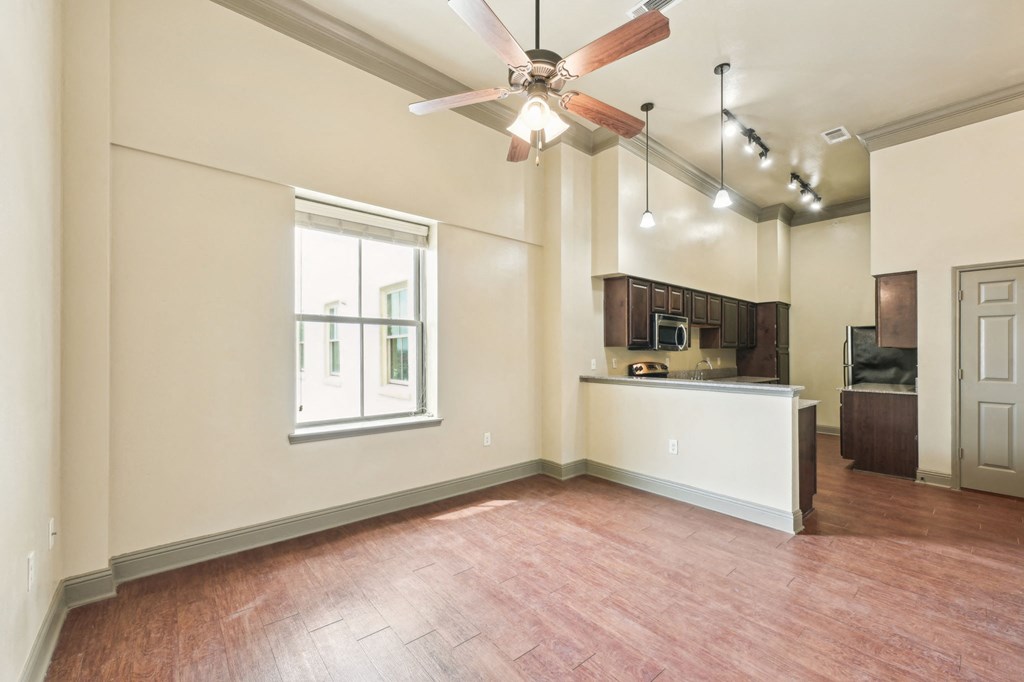 A room with a ceiling fan and wooden flooring.