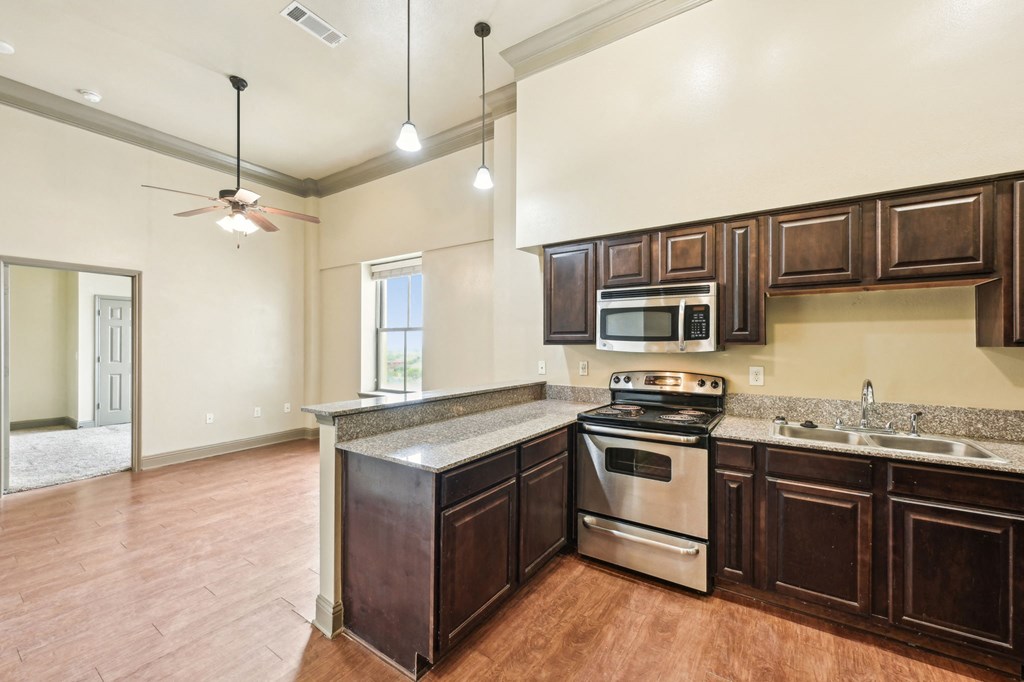 A kitchen with wood cabinets and a stainless steel stove.